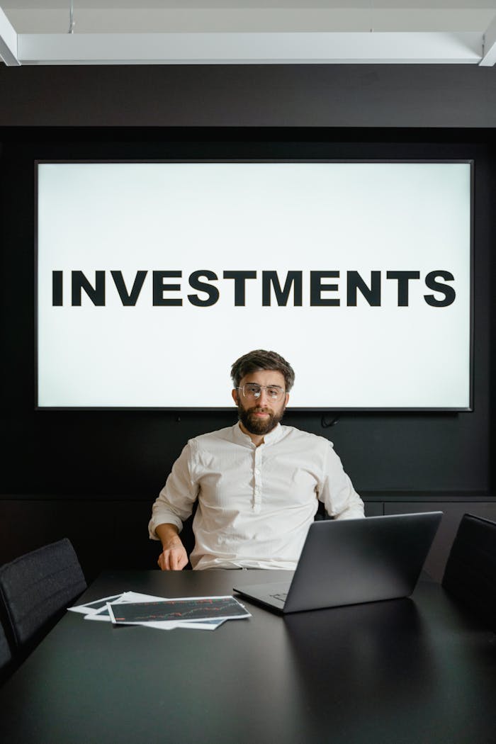 Services Man in office with investment presentation on screen and papers on table.